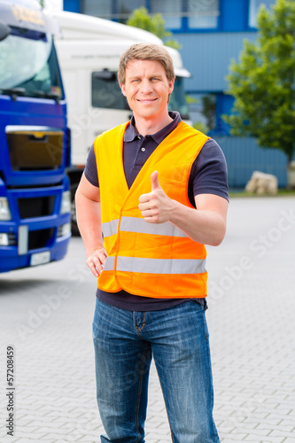 Spediteur vor Lastwagen und LKW auf Depot