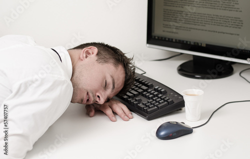 tired businessman sleeping on computer