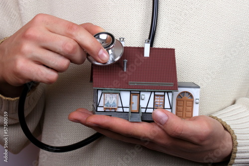 Haus wird mit Stetoskop abgehört, Hauskauf
