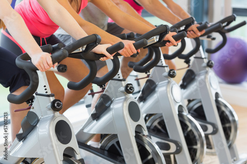 Mid section of people working out at spinning class