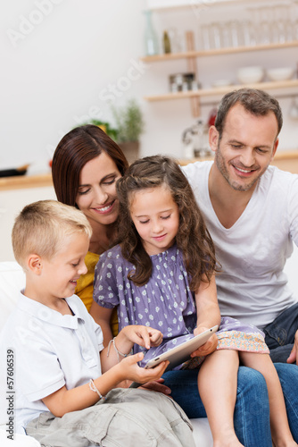 eltern und kinder schauen auf tablet