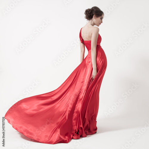 Young beauty woman in fluttering red dress. White background.