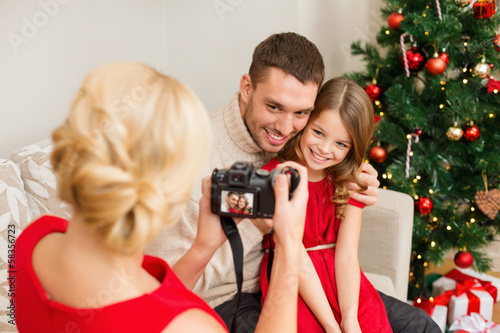 mother taking picture of father and daughter