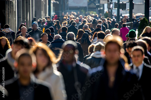 Anonymous crowd of people walking on city street