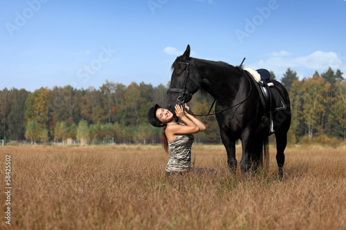 Piękna młoda dziewczyna bawi się z koniem.