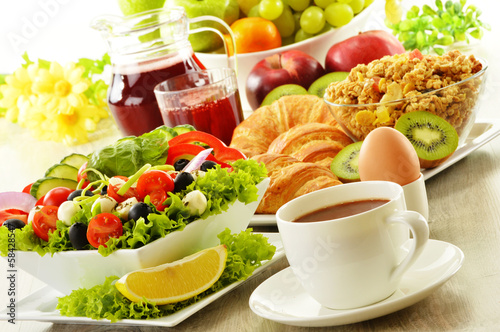 Breakfast with coffee, juice, croissant, salad, musli and egg