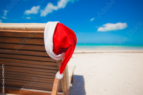 Santa hat on chair longue at tropical caribbean beach