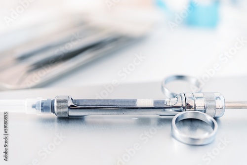 Empty dental syringe on steel surface