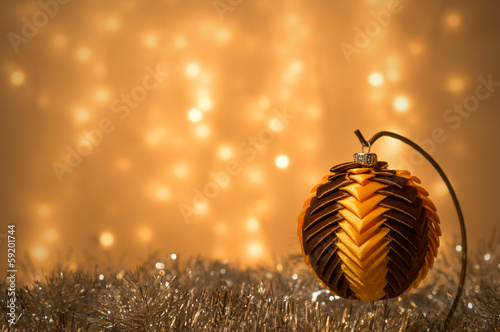 Dekoracja świąteczna - bombka ze wstążek na tle lampek