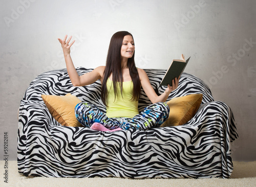 Inspired girl sitting on the sofa and reciting a poem