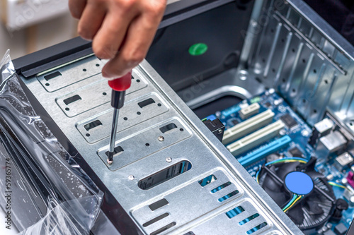 Close-up of technician's hand assembling personal computer