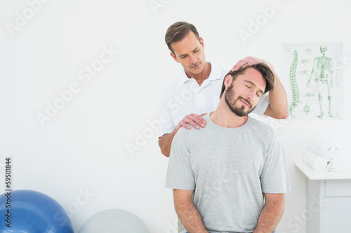 Male chiropractor doing neck adjustment