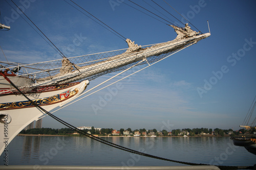 Bowsprit of a sail ship with city in the background