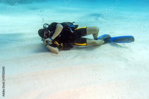 Diver Sleeping on Sandy Sea Bottom