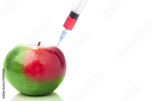 Apple in two colors with a syringe. Concept for GMO.