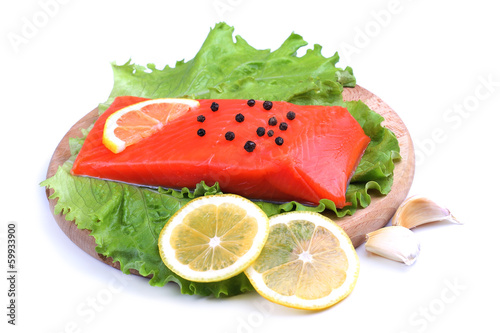 Trout fillet with lemon, garlic and lattuces leaves on white