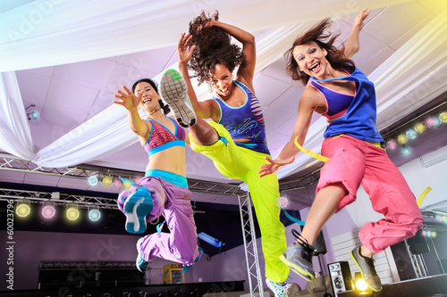 young women in sport dress jumping at an aerobic and zumba exerc