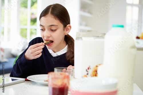 Schoolgirl With Digital Tablet And Mobile Eating Toast