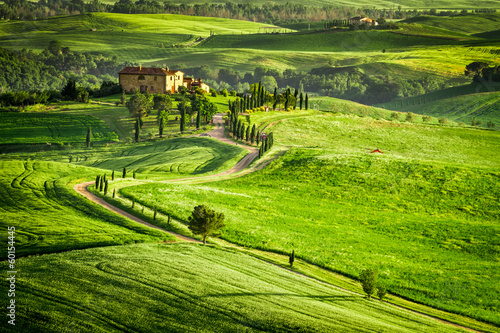 Sunset over farmhouse in Tuscany located on a hill