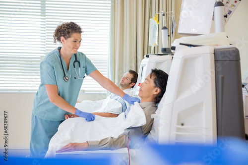 Nurse Assisting Patient Undergoing Renal Dialysis