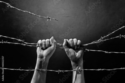 hand behind barbed wire