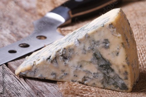 Blue cheese on sackcloth close up on an old wooden table