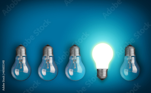 Idea concept with row of light bulbs and glowing bulb