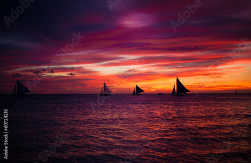 Incredible beautiful sunset with sailboat on the horizon in