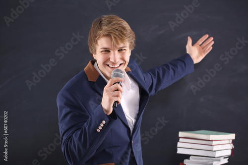 Młody mężczyzna z mikrofonem podczas energetycznej prezentacji