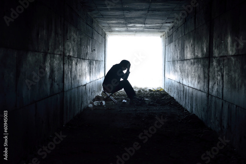 depressed man sitting in the tunnel