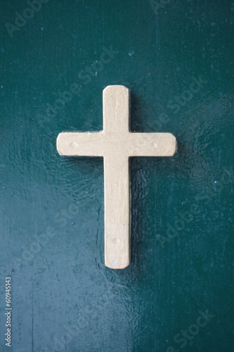 bronze cross on green background