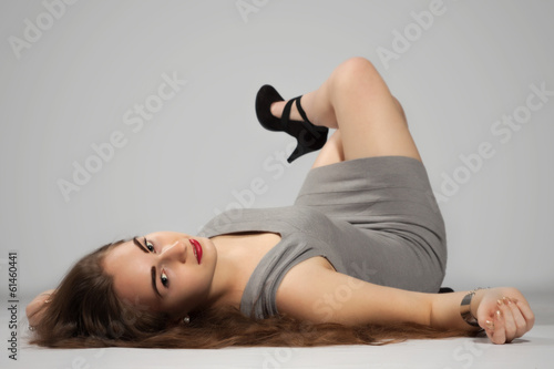 Long-haired teenager girl in gray minis and black high heels