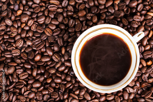 A cup of hot coffee on beans background