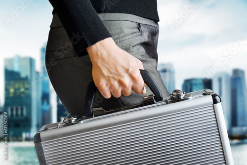 Business woman holding an aluminium briefcase