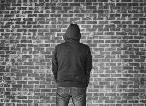 Young man covered his head against wall,black and white 