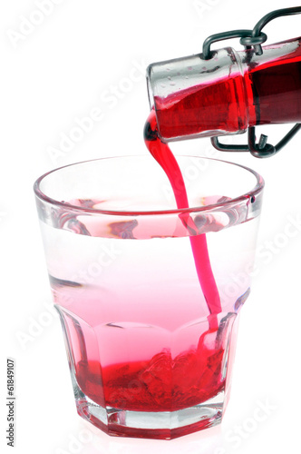 Sirop de grenadine versé dans un verre d'eau