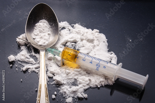 Drug syringe and cooked heroin on spoon