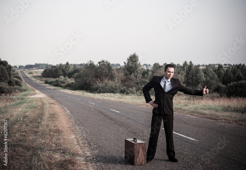 young men hitchhiking on a road