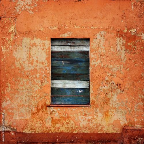 orange wall with a board up window