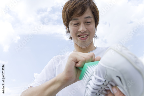 man washing sneakers