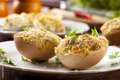 Baked eggs, stuffed with ham and parsley