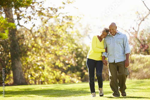 Senior Couple Walking Through Autumn Woodland