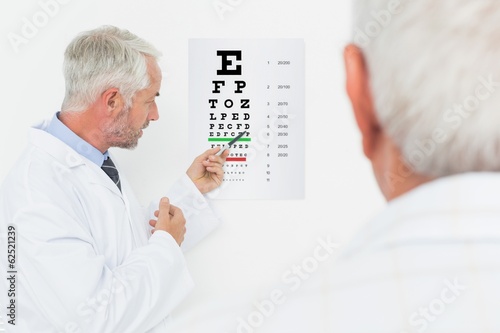 Pediatrician ophthalmologist with senior patient pointing at