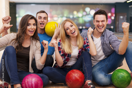 Portrait of smiling friends at the bowling alley.