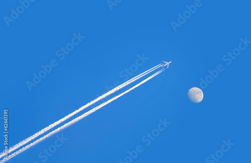 jet airplane on blue sky with moon