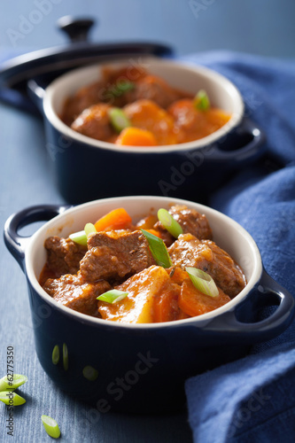 beef stew with potato and carrot in blue pots