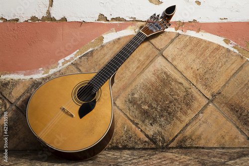 traditional portuguese guitar on a stone bench.