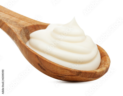 Cream in wooden spoon isolated on white background.
