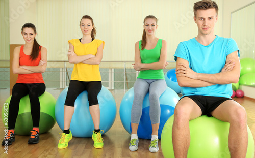 Young beautiful peoples engaged with balls in gym