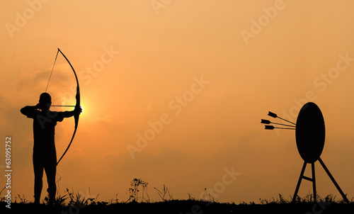 Silhouette archery shoots a bow at the target.